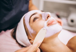 Cosmetologist applying mask face client beauty salon