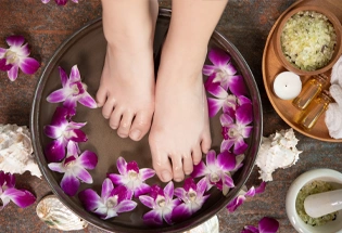 Spa treatment product female feet hand spa orchid flowers ceramic bowl